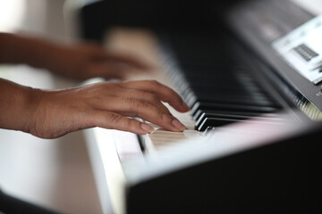Close-up of a music performer's hand playing the piano , Piano keyboard background with selective...