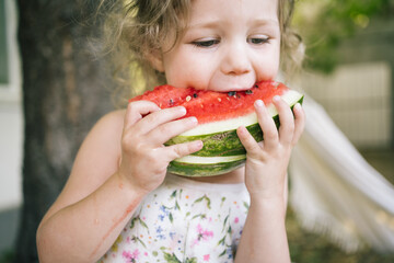 Little child eating fresh watermelon