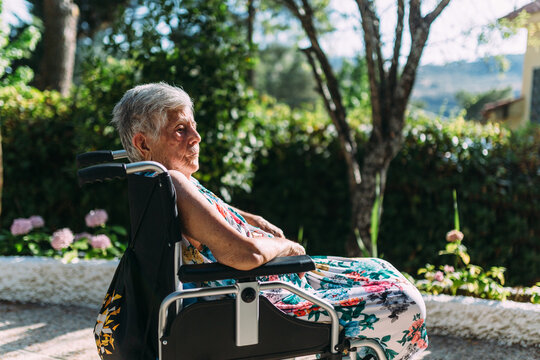 Elderly woman sitting outdoor at sunset