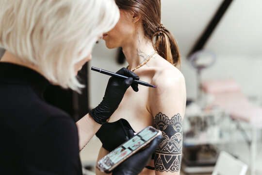Female artist in the process of making a tattoo.