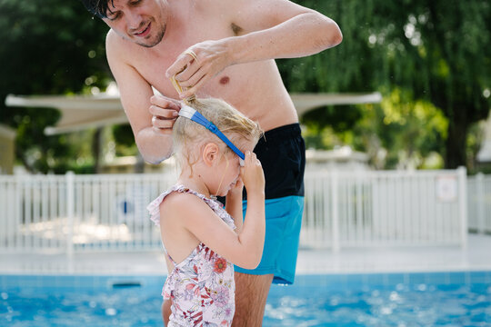 Father and daughter by the swimming pool