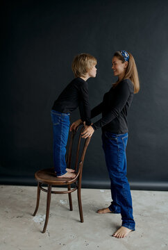 mother and son in the Studio on a black paper background in jeans and a black long sleeve jacket
