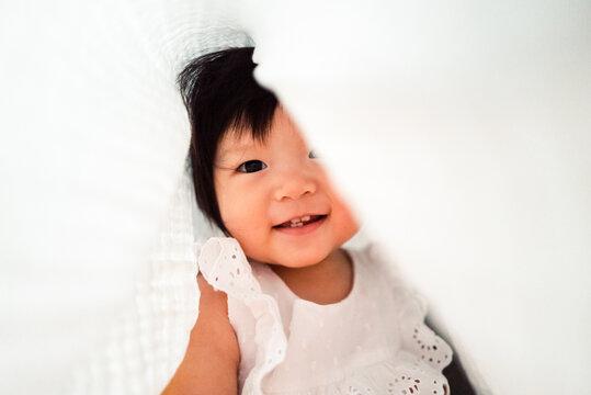 Little girl hiding under the quilt