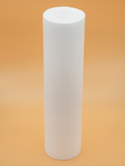 One clean, new filter cartridge purifiers for running water on a gold fortune background. The concept of pre-cleaning, water softening, deep sorption cleaning.