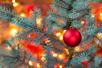 Bright Christmas tree with red ornament hanging