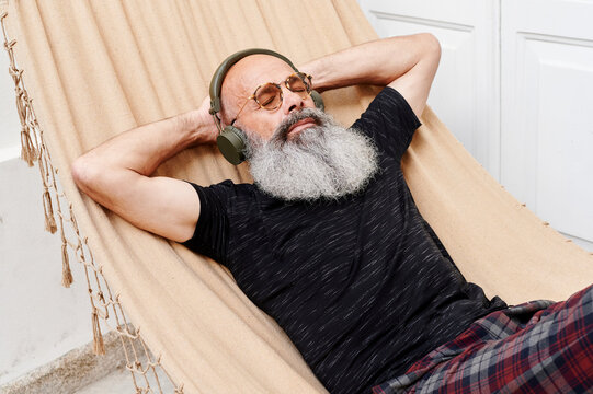 Mature man listening to music on a hammock