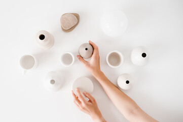 Crop person arranging ceramic vases