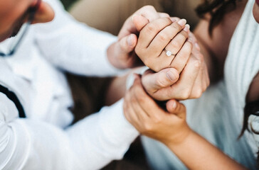 newly engaged couple holding hands and showing of the engagement ring