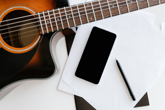 Guitar and smartphone on table