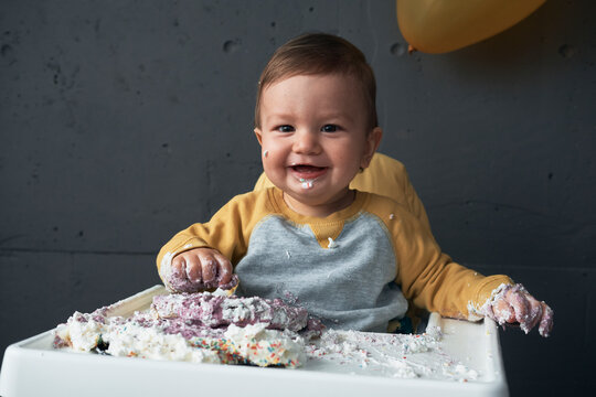 Baby boy smashing birthday cake.