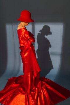 woman playing with red silk fabric on blu background