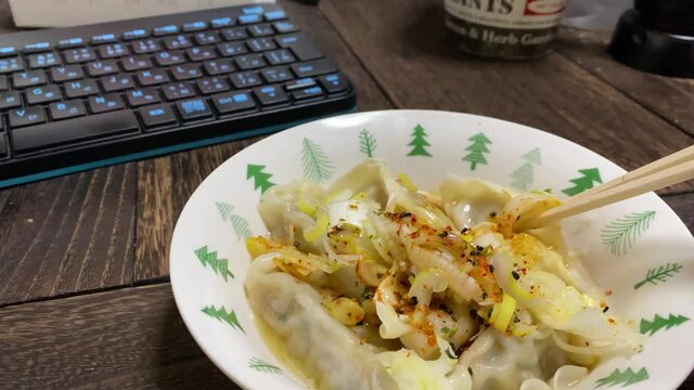 刻みネギと七味唐辛子をかけた水餃子をいただきます。庶民的な食事/平凡な食生活/リアル感漂う日常。