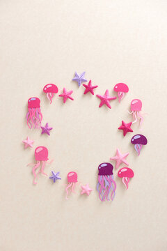 Many beautiful jellyfish and different starfish over beige background