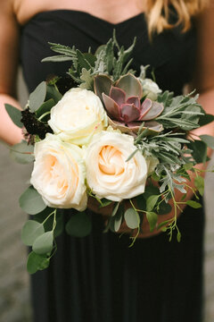 bridesmaid with cute black dress and flower bouquet