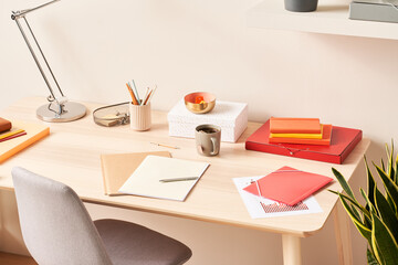 Stationery and mug of tea on table