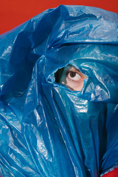woman covering her face with a blue plastic sheet