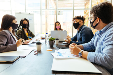 Business team wearing protective masks while meeting in the office during the COVID-19 epidemic