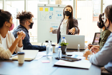 Business team wearing protective masks while meeting in the office during the COVID-19 epidemic