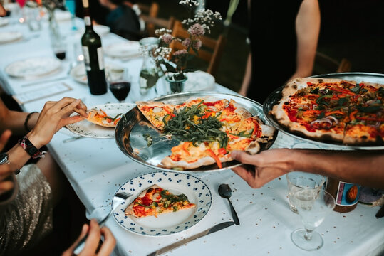serving pizza at a table outdoors by dusk