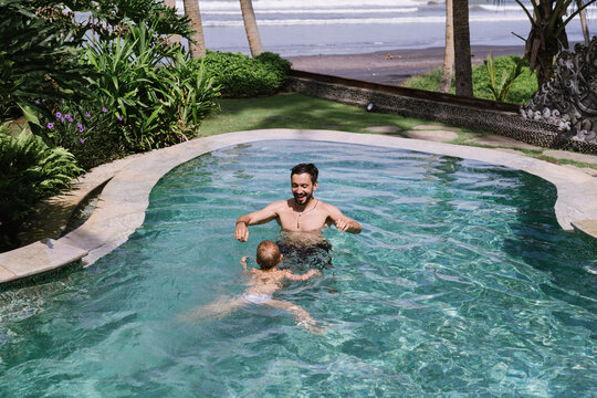 Dad Swimming With A Kid In A Pool