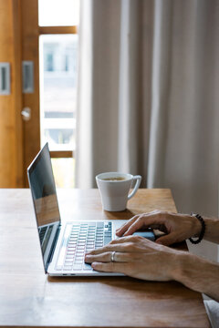 Crop man typing on laptop