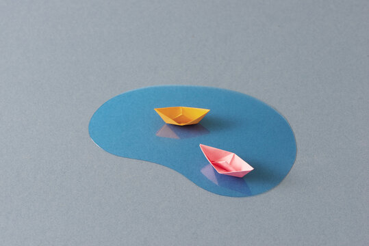 origami boat sailing in blue ocean , paper art style