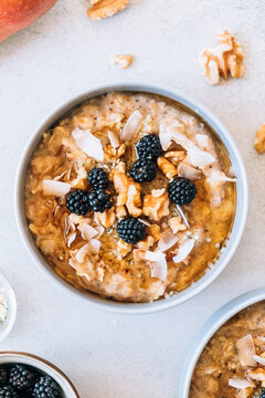 Homemade porridge topped with wild blackberries, walnuts and shr