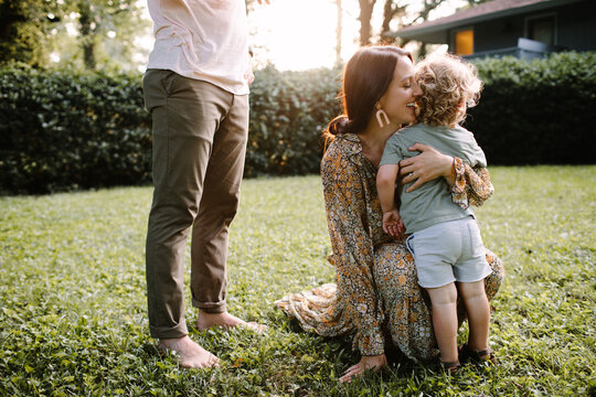 Mom Kneeling Down to Hug Young Son