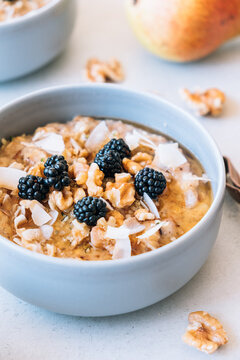 Homemade porridge topped with wild blackberries, walnuts and shr