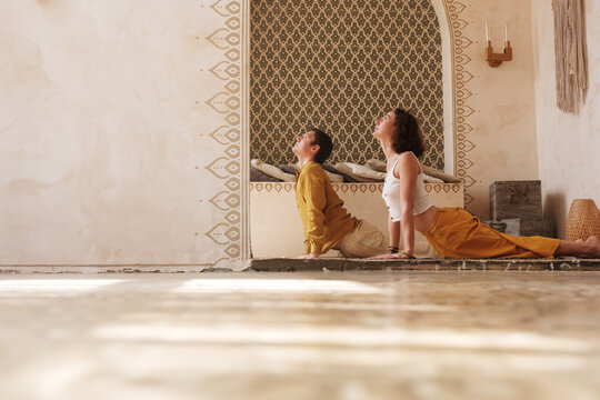 Flexible man and woman in Upward Facing Dog pose