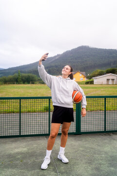 Girl Taking A Selfie On The Basketball Court.