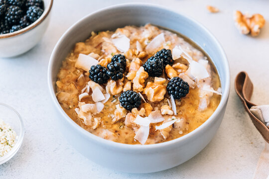 Homemade porridge topped with wild blackberries, walnuts and shr