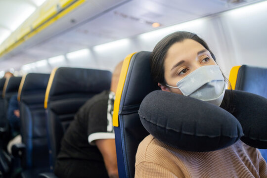 Woman With Face Mask Resting On A Plane.