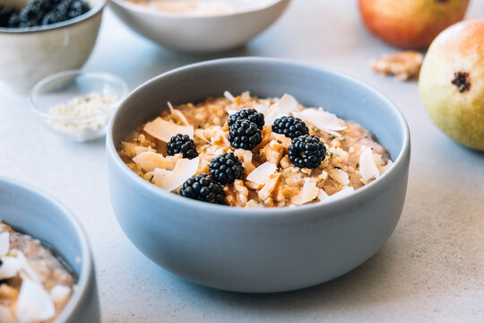 Homemade porridge topped with wild blackberries, walnuts and shr