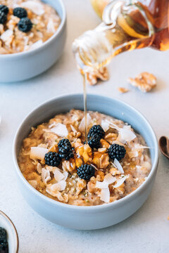 Homemade porridge topped with wild blackberries, walnuts and shr