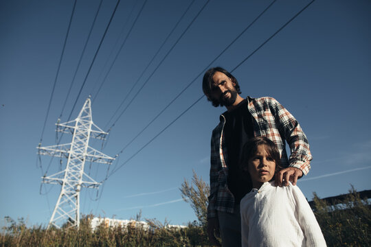 Father and little son at the power line tower