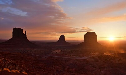 Fototapeta na wymiar sunset in winter behind the spectacular mitten buttes and merrick butte from the view hotel in the navajo tribal park of monument valley, utah 