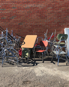 School Desks and Chairs Stacked Outside Building