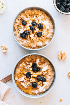 Homemade porridge topped with wild blackberries, walnuts and shr