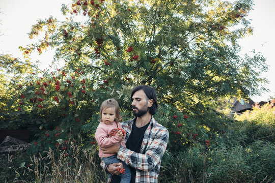 Father and little daughter at the rowan tree