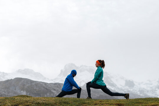 Multi generational couple warming up during workout in nature