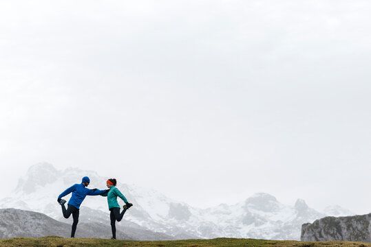 Trail runners on mountain scenery on cloudy day