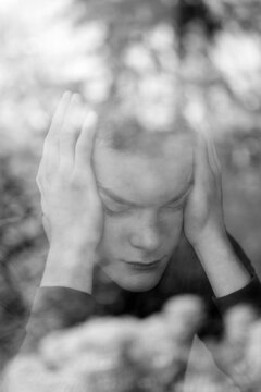Depressed young man behind dirty window glass