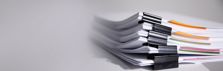 Pile of unfinished documents on office desk