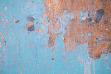 Blue rusty grunge metal texture background. An old metal wall painted with multi-layered light blue paint that shows a lot of dark spots and rust stains on the paint.