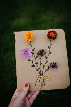 holding a cardboard with flowers