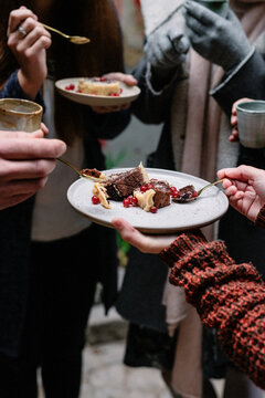 sharing a Christmas dessert with chocolate and red berries outdoors with a fire pit