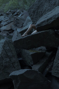 a man's leg peeps out from under the cut granite