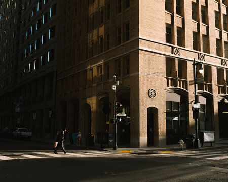 man crossing street during sunset