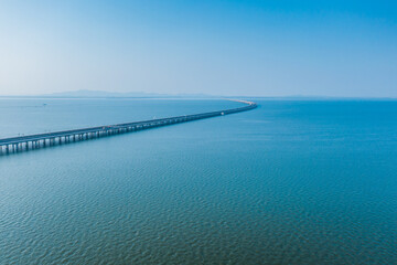 Aerial view of bridge road with cars over lake or sea